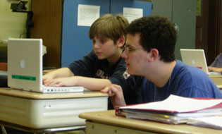 Student helping a child on a computer