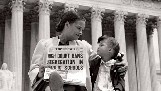 Woman and child in front of US Supreme Court, holding newspaper reading "High Court Bans Segregation in Public Schools"