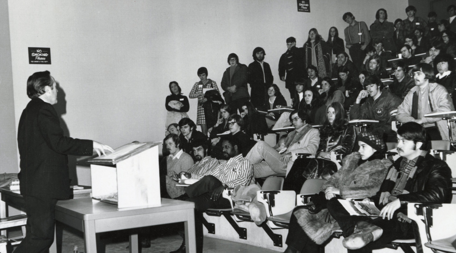 Professor lecturing to a crowded auditorium