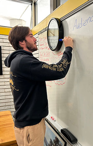 Mike Lynch writes on a dry erase board