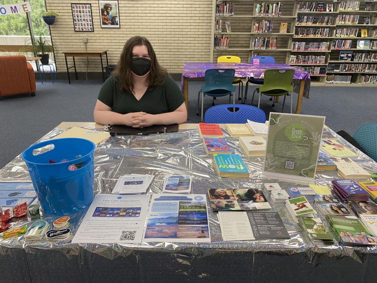 College counselor sits at table for green dot and calm app promotion