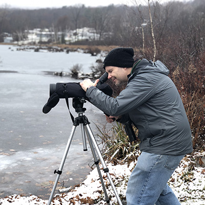 Faculty taking video on a frozen lake